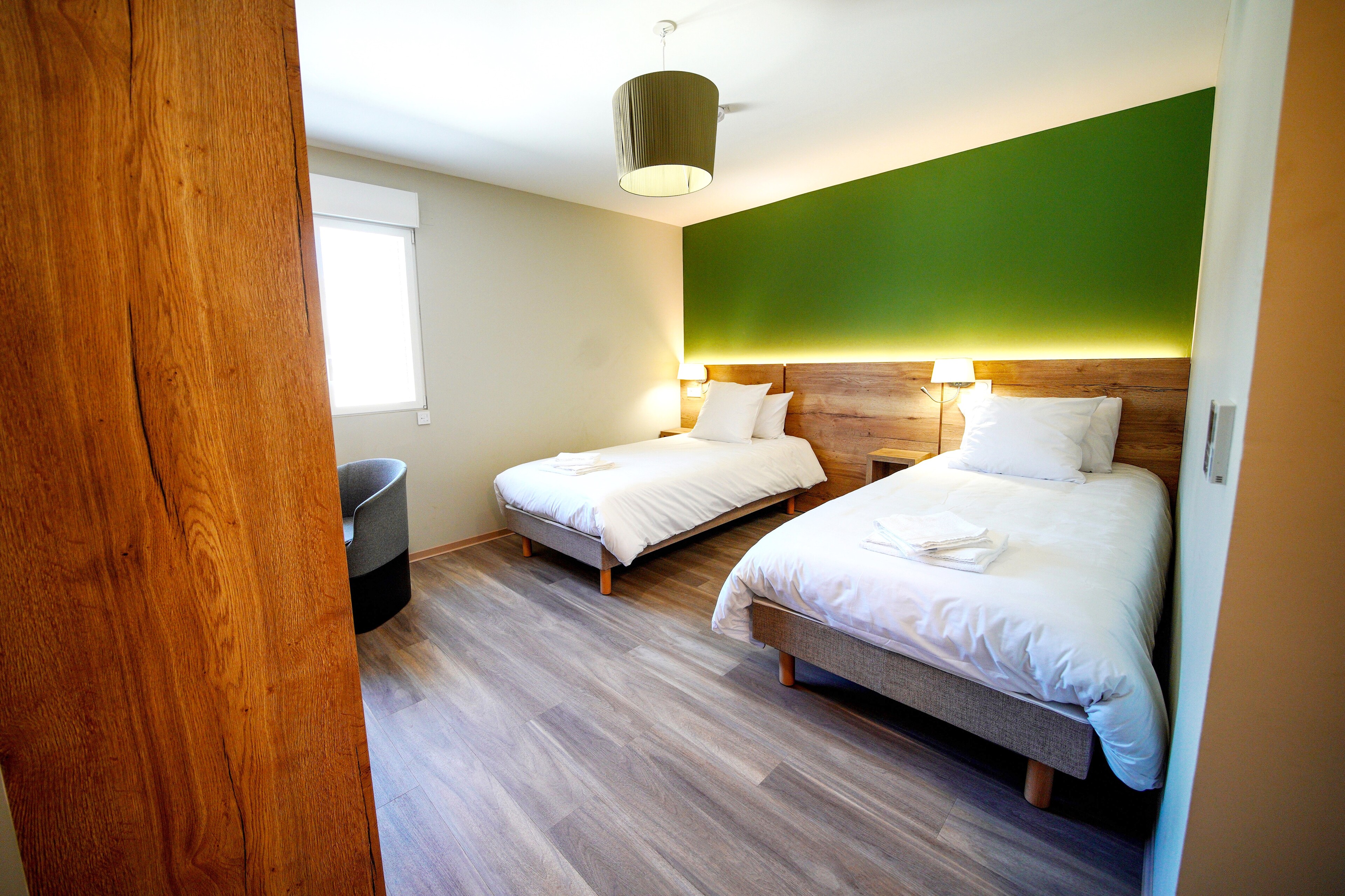 L'image représente une chambre avec 2 lits simples et accessible aux personnes à mobilité réduite. Elle permet d'accéder à la catégorie 