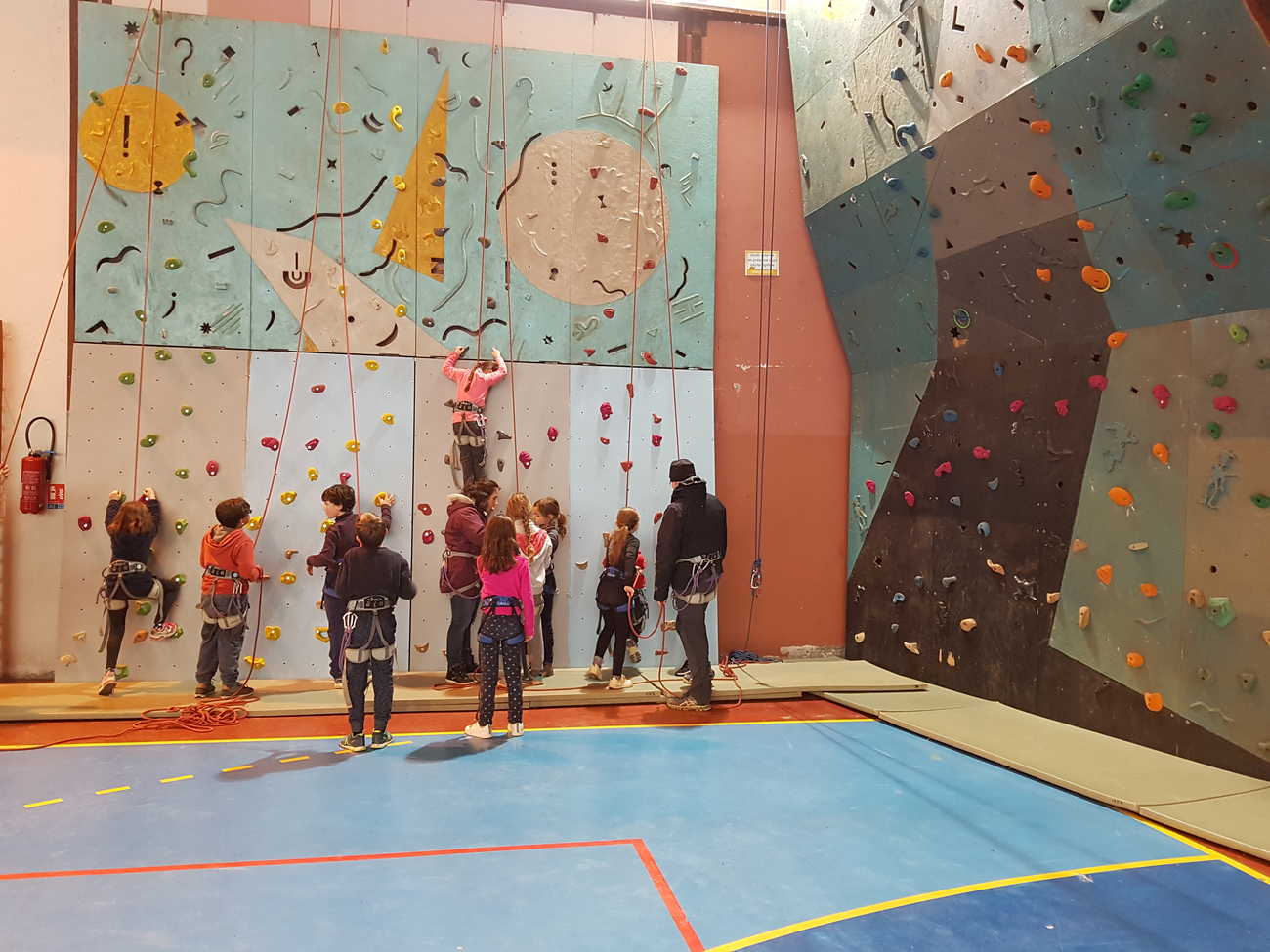 Mur d'escalade avec enfant à l'intérieur du gymnase
